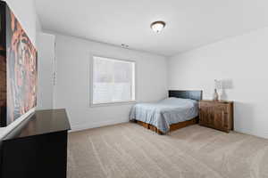 Carpeted room featuring a window with blinds, white walls, and a semi-flush mount ceiling light