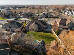 Expansive backyard featuring a large manicured lawn, mature trees, and privacy fencing