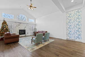 Vaulted ceiling living area featuring a prominent fireplace with a white marble surround and black firebox