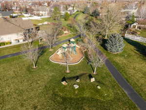 Community playground with a multi-level structure, surrounded by a manicured lawn and mature trees