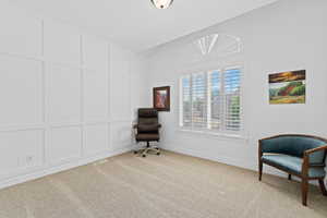 Window-filled room featuring board and batten wall detailing, plantation shutters, and a sunburst transom window
