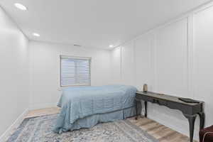 Room featuring wood-finish flooring, recessed lighting, and a window with blinds