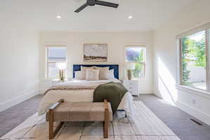 Spacious room featuring plush carpeting, a large picture window, two additional windows with roller shades, a ceiling fan, and recessed lighting