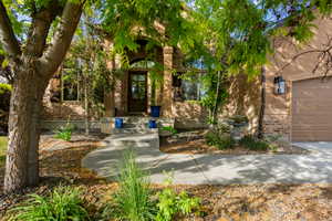 Exterior showcasing a brick and stucco facade, an arched entryway, and a concrete pathway
