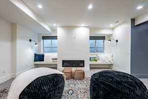 Recessed lighting illuminates this bright space featuring a built-in electric fireplace and two window seats with integrated storage