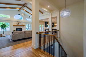 Grand entryway featuring a decorative spherical pendant light, hardwood flooring, and a staircase with wood handrails and black metal balusters