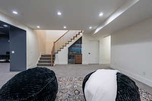 Lower level entertainment space featuring recessed lighting and gray carpeting