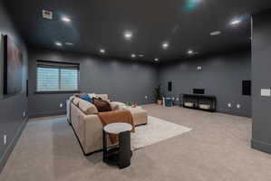 Spacious room featuring dark gray walls, recessed ceiling lighting, and light-toned carpeting