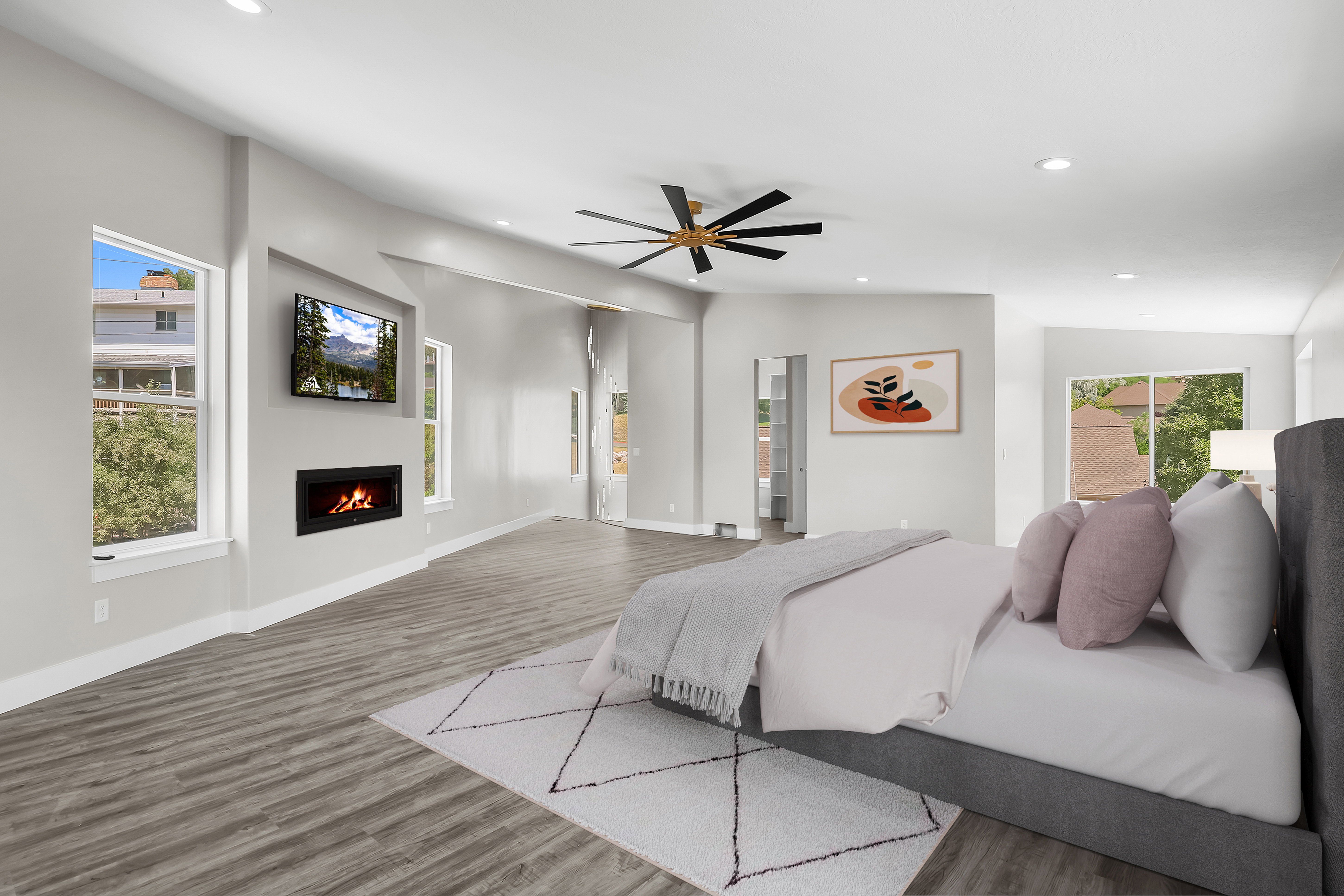 Primary Bedroom /VIRTUAL STAGING! Spacious room featuring wood-finish flooring, an inset linear fireplace, multiple large windows, recessed lighting, and a modern ceiling fan