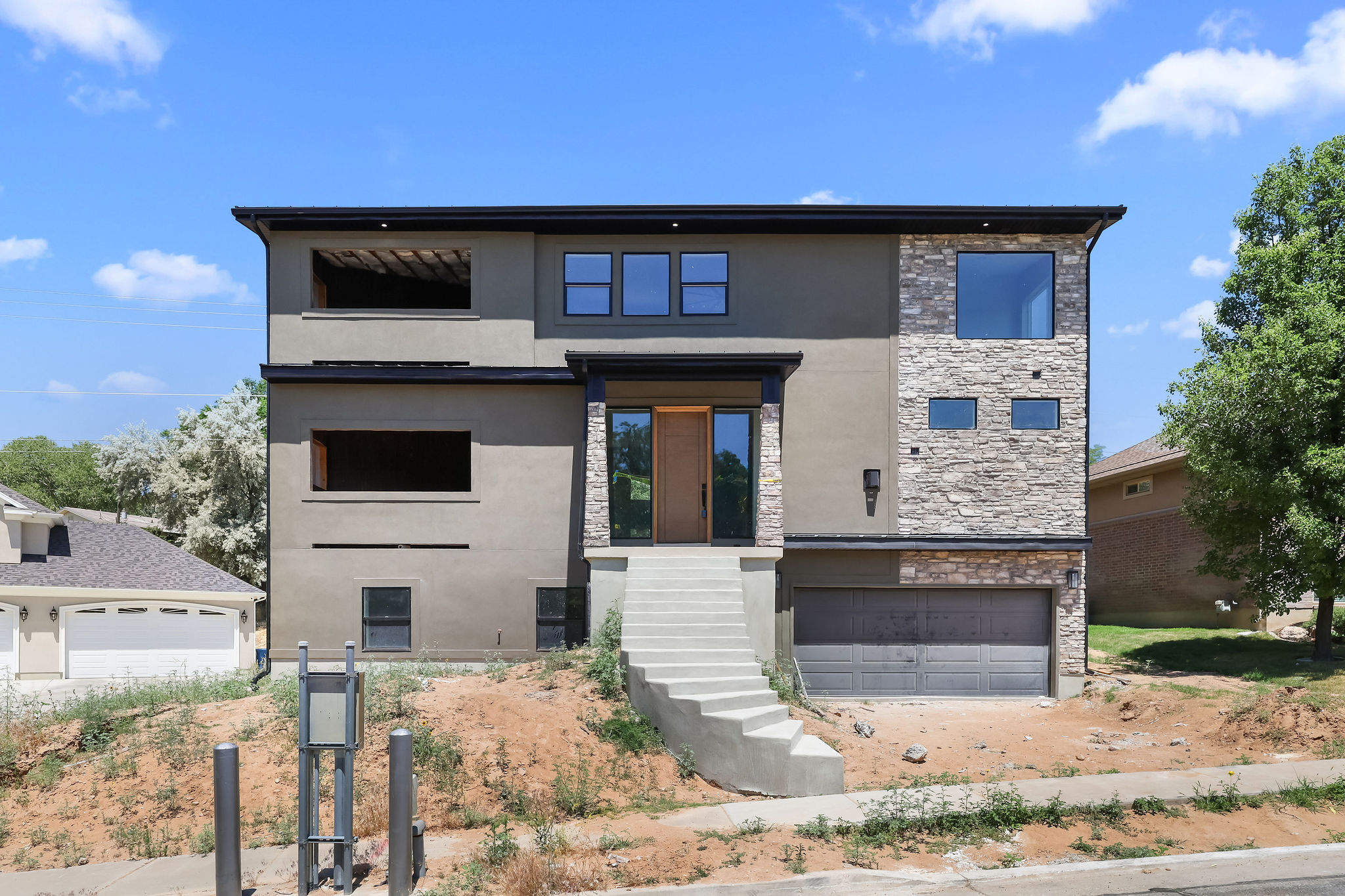 Contemporary multi-level residence featuring a stucco and stone veneer exterior