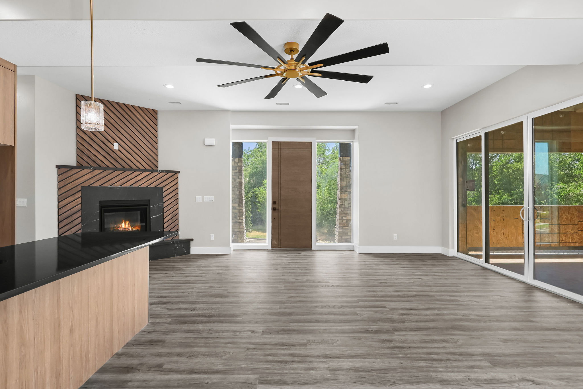 Open living area featuring wood-finish flooring, a contemporary ceiling fan, and recessed lighting