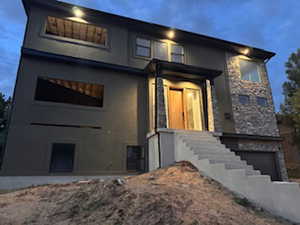 Contemporary facade featuring stone accents, a multi-story design, and an integrated garage