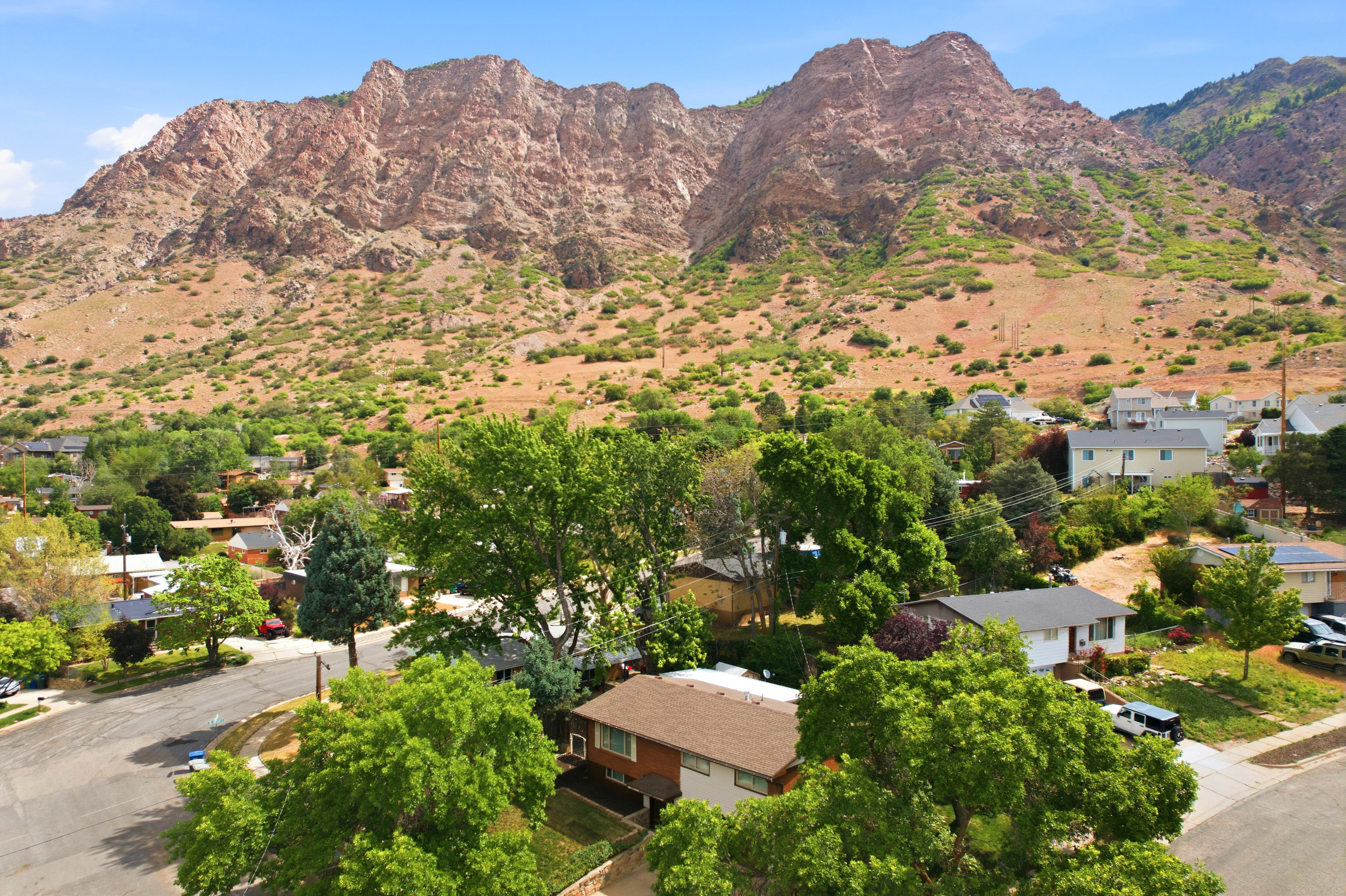 Mountainous terrain backdrop featuring a residential setting with mature trees and paved streets