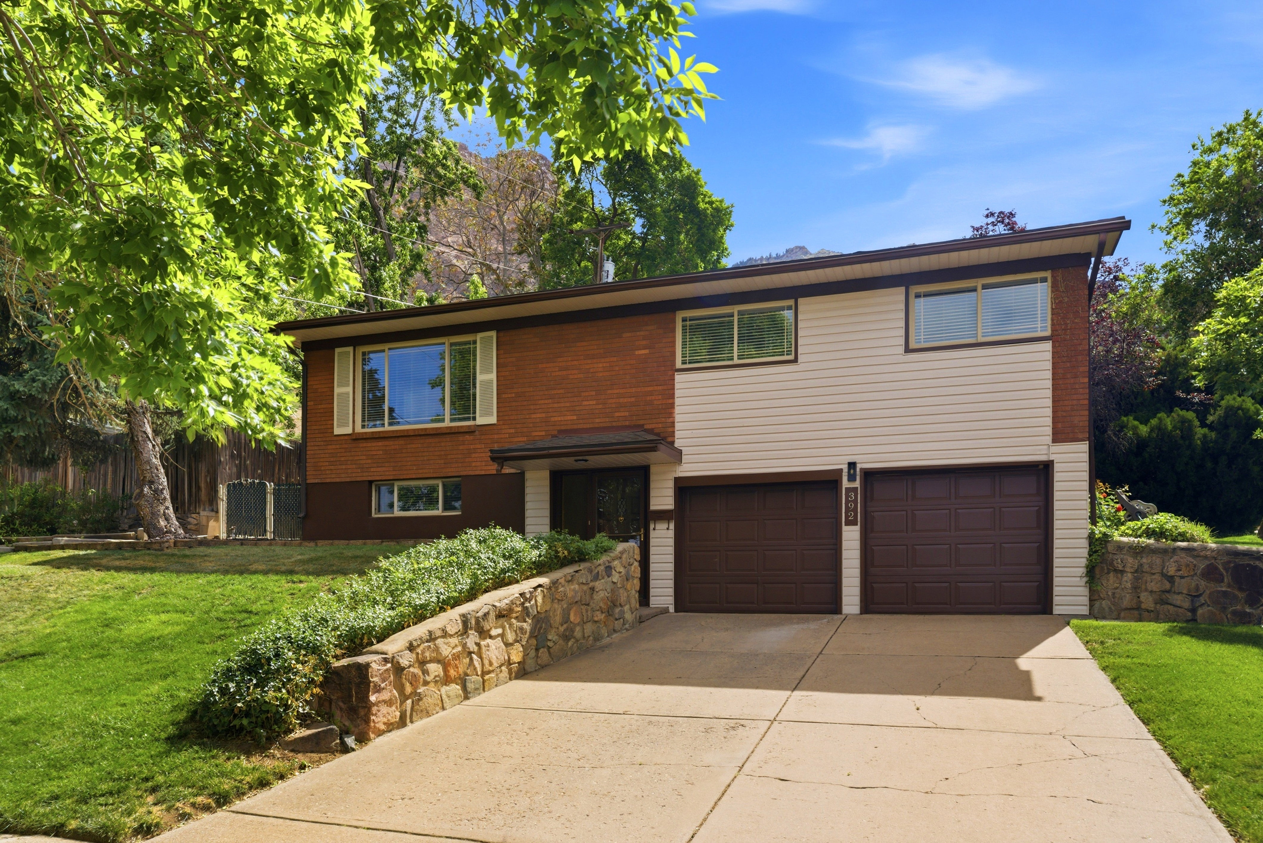 Two-story exterior featuring brick and horizontal siding, with a two-car garage