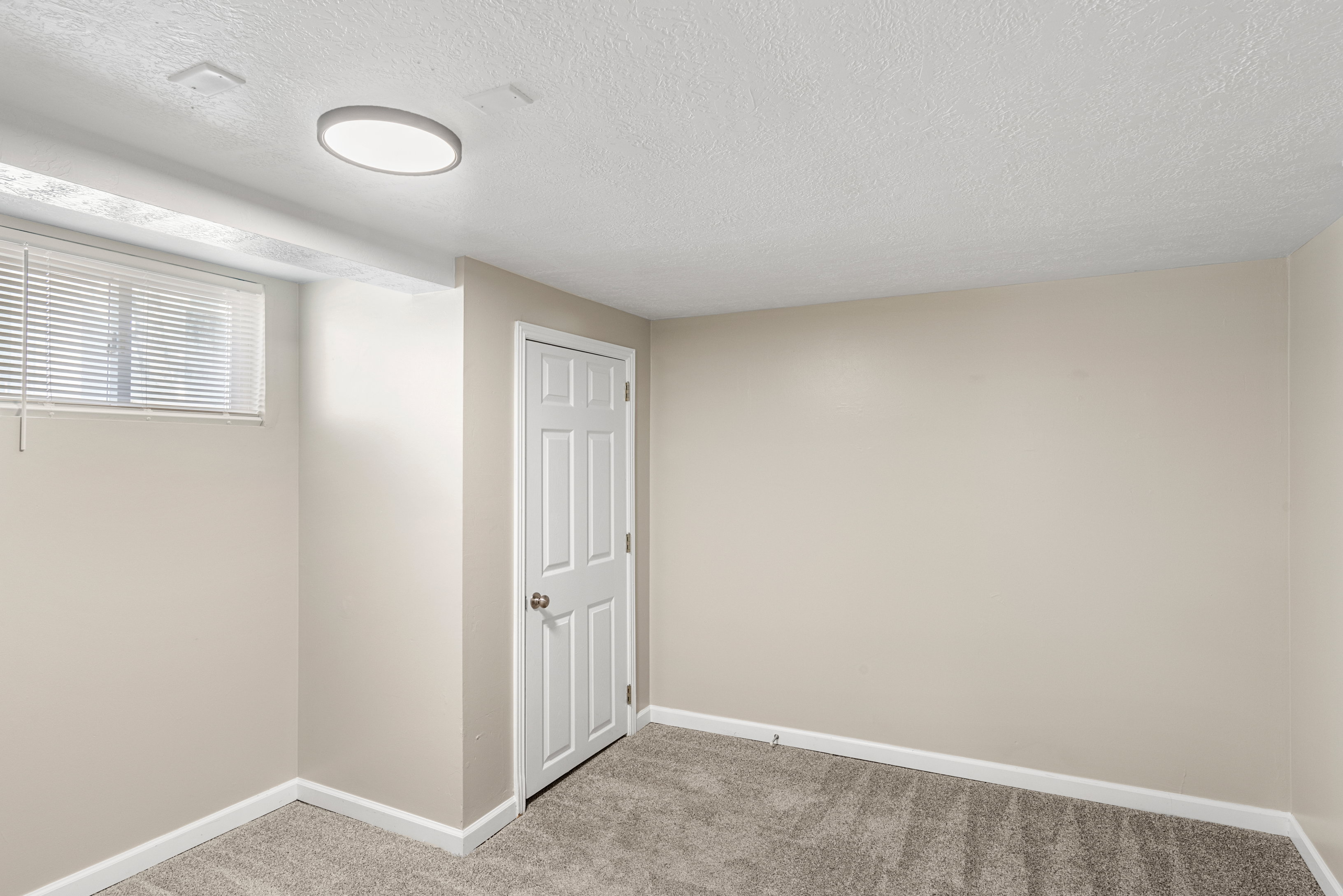 Basement bedroom with two-tone paint, LED lighting, and carpet flooring