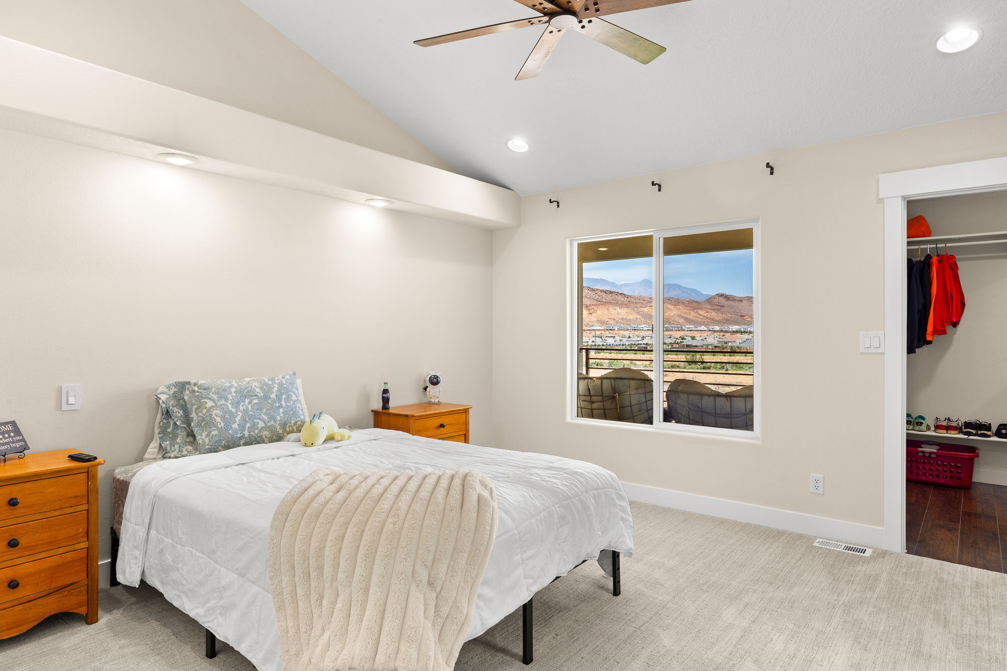Room featuring a window with distant mountain scenery, vaulted ceiling, recessed lighting, and a ceiling fan