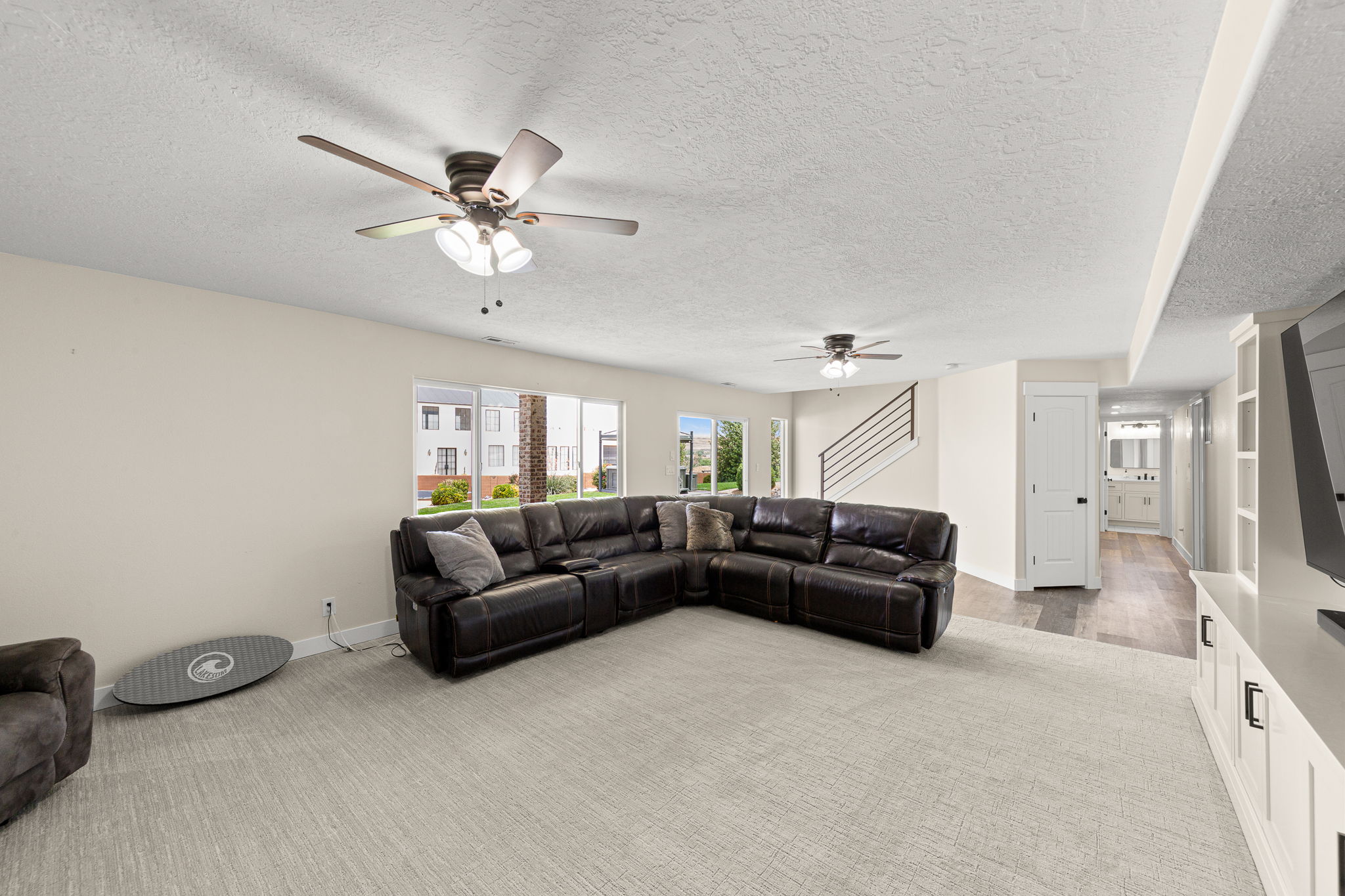 Spacious living area featuring light carpeting and neutral wall tones
