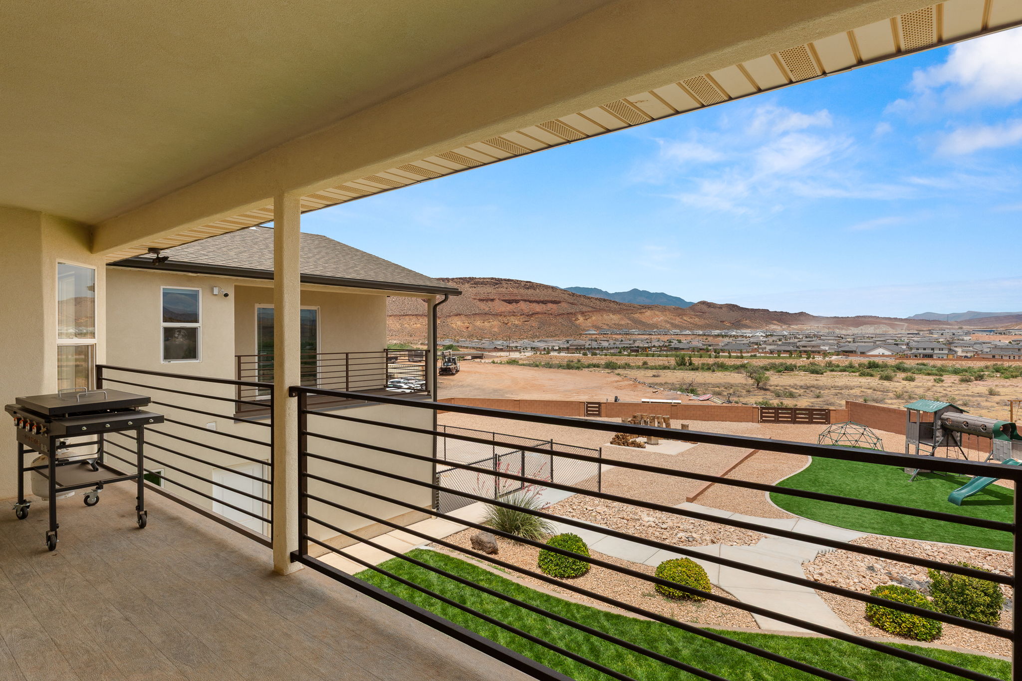 Covered outdoor living space featuring wood-finish flooring and black horizontal railings