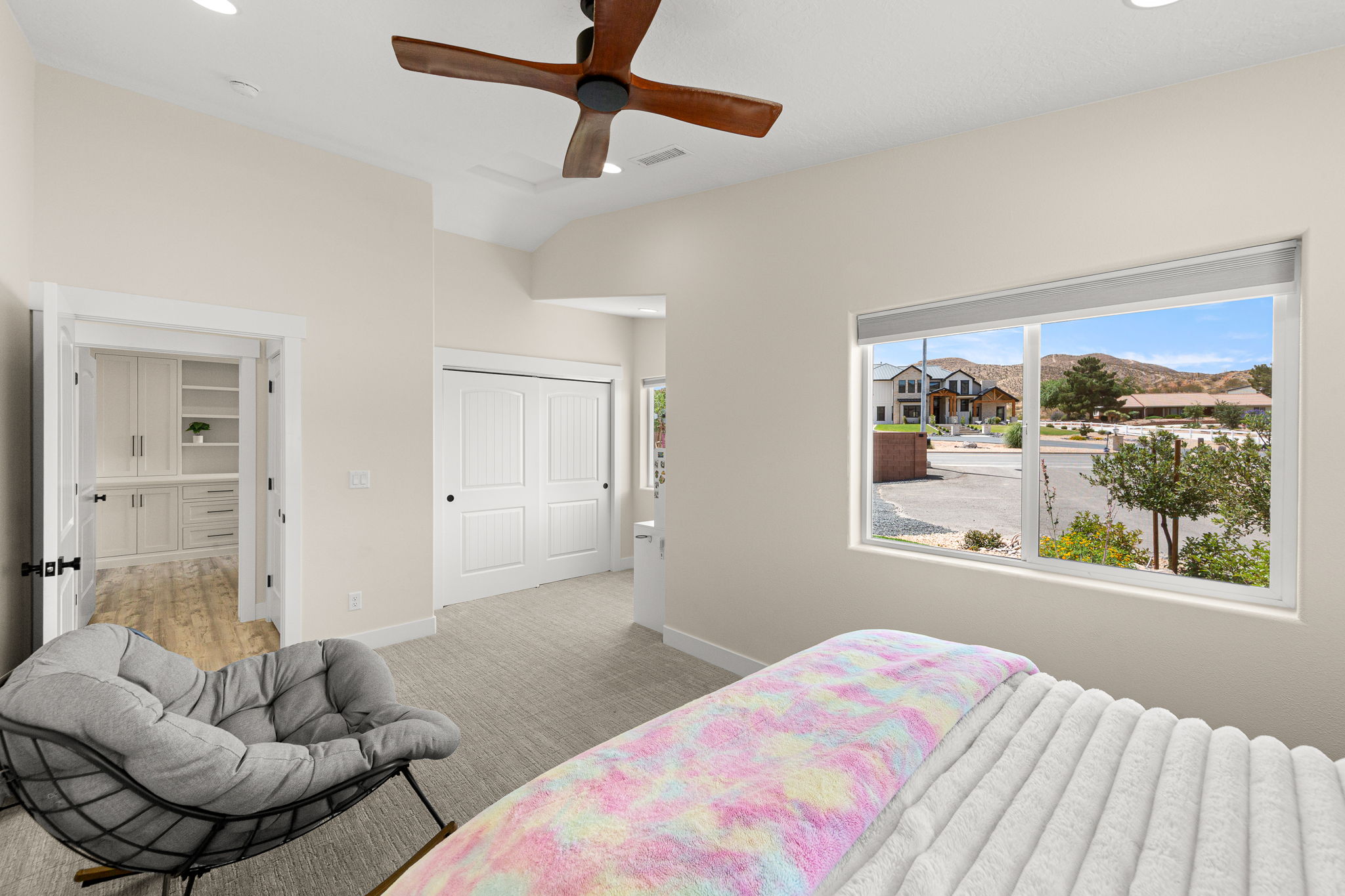 Spacious interior room featuring a large window, vaulted ceilings, and recessed lighting