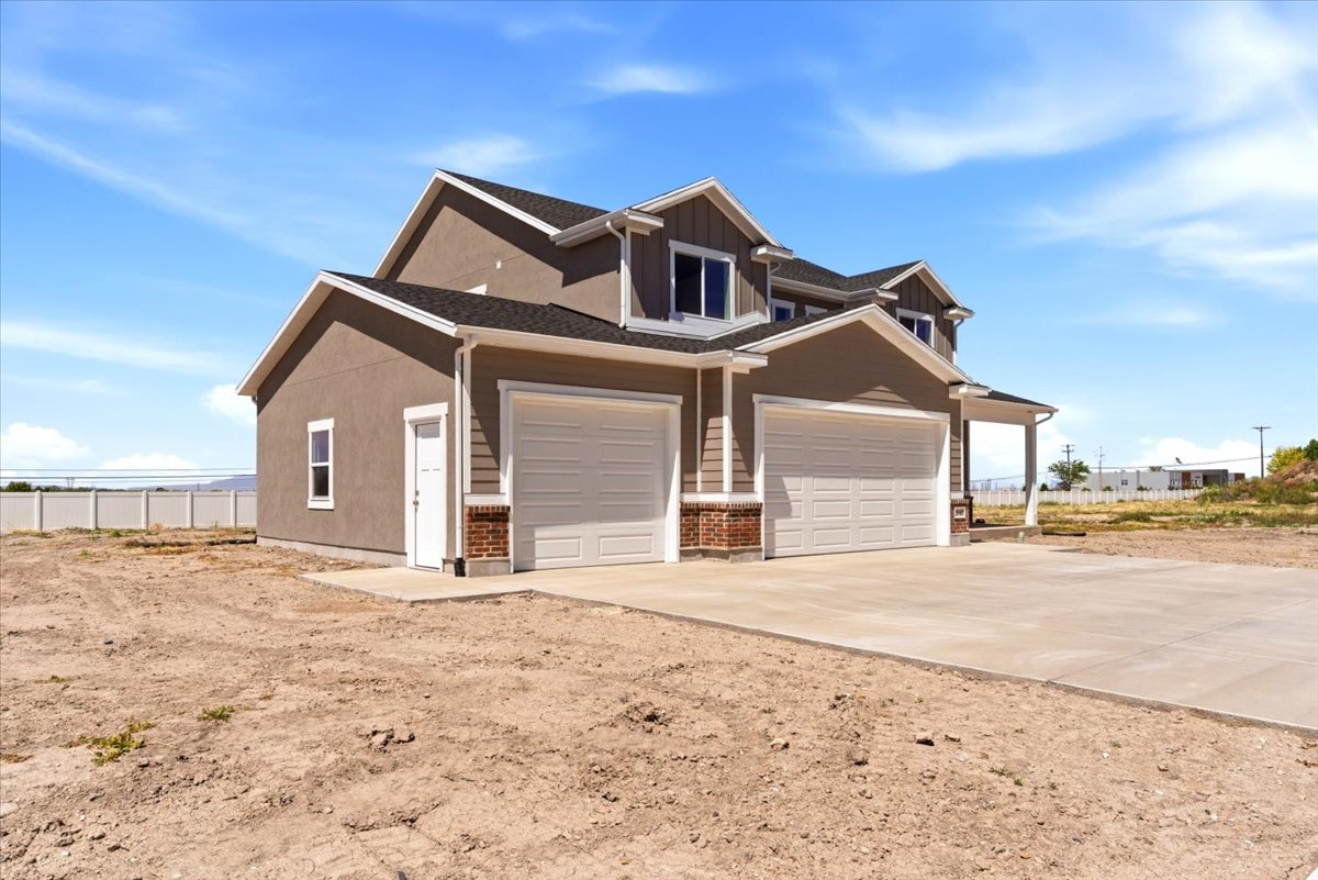 Two-story exterior featuring a neutral stucco and siding facade, contrasting white trim, and a dark shingled roof