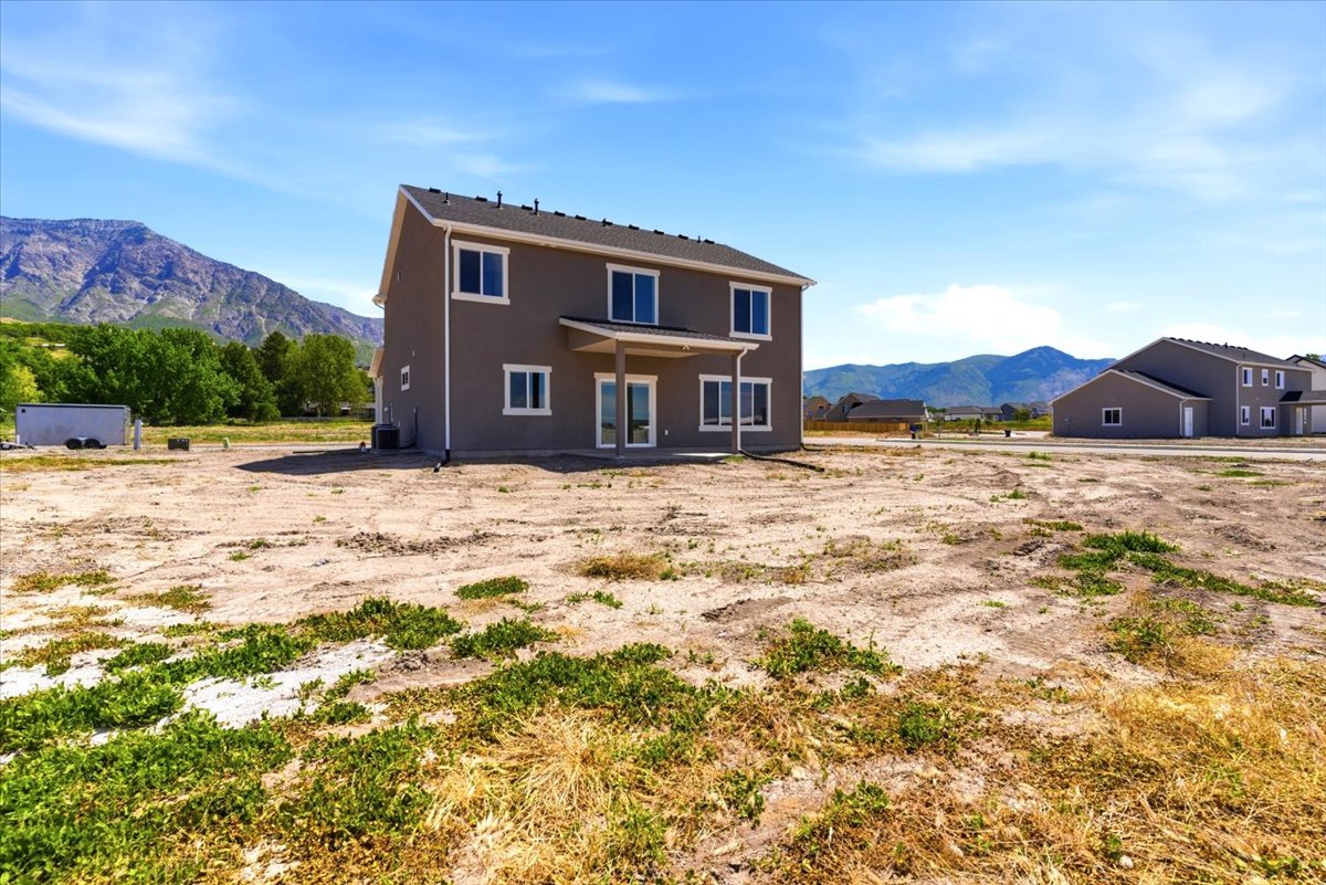 Contemporary two-story residence featuring a covered patio, multiple windows, and a neutral exterior finish