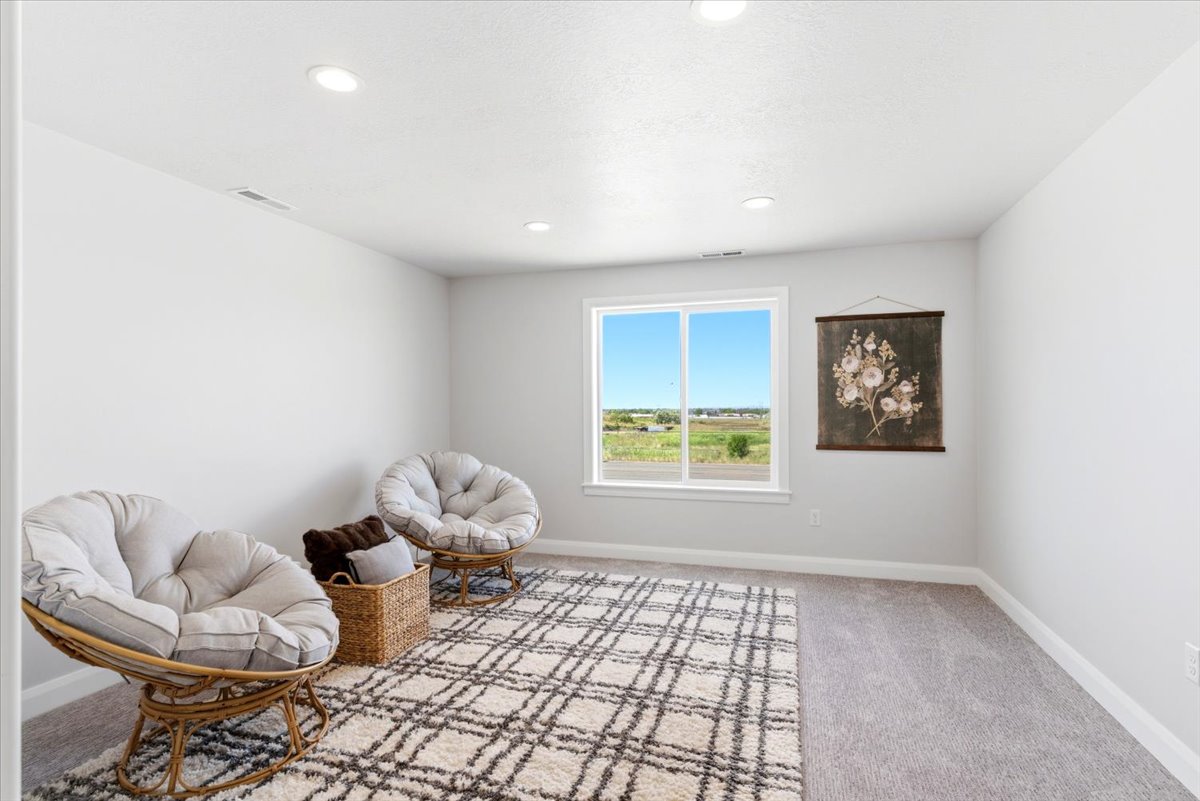 Spacious room featuring a large window, recessed lighting, neutral wall tones, and plush carpet