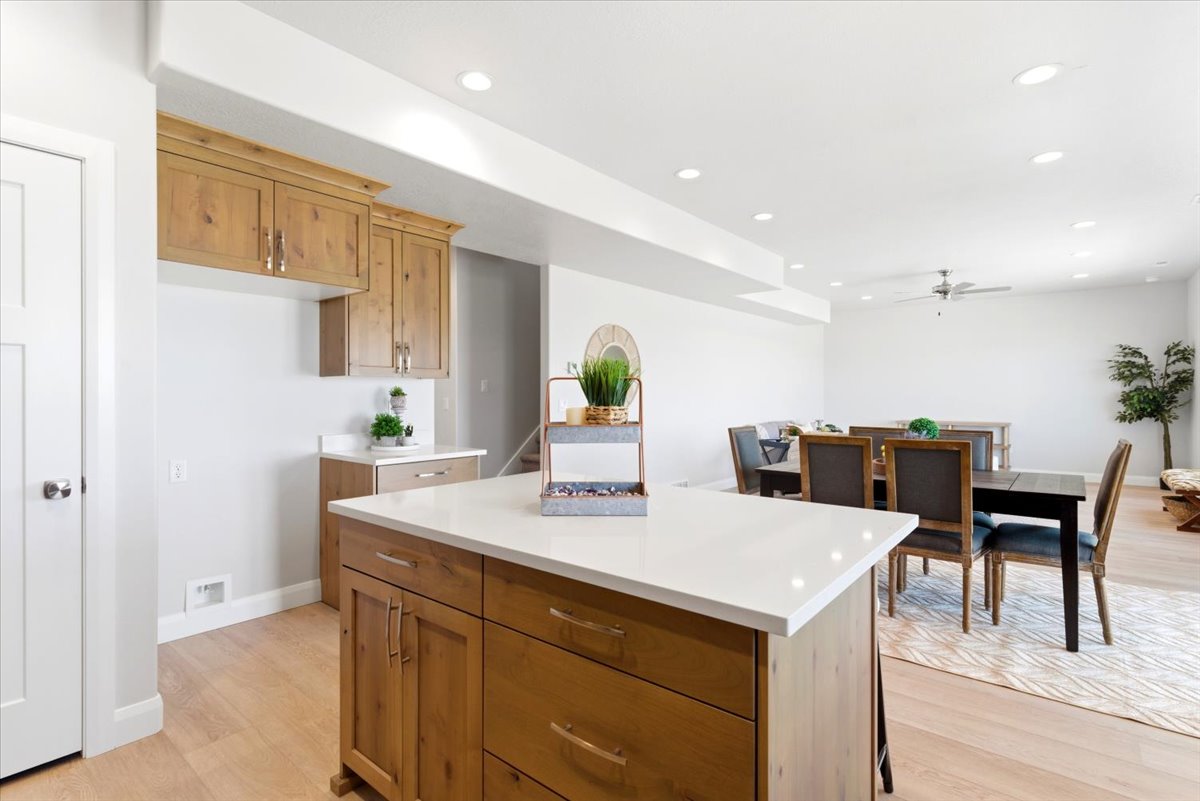 Kitchen island with a white solid surface countertop and wood-finish cabinetry