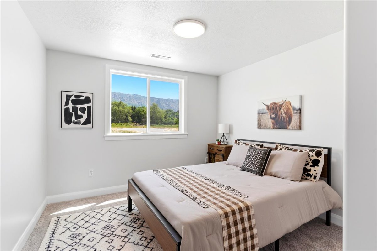 Bedroom featuring a large window, neutral carpeting, and white walls