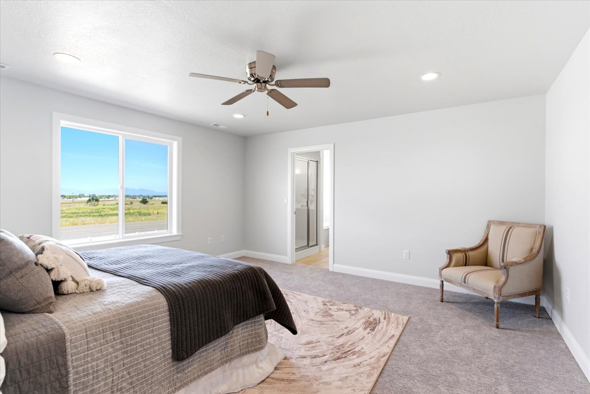 Spacious bedroom featuring a large window, recessed lighting, and a ceiling fan