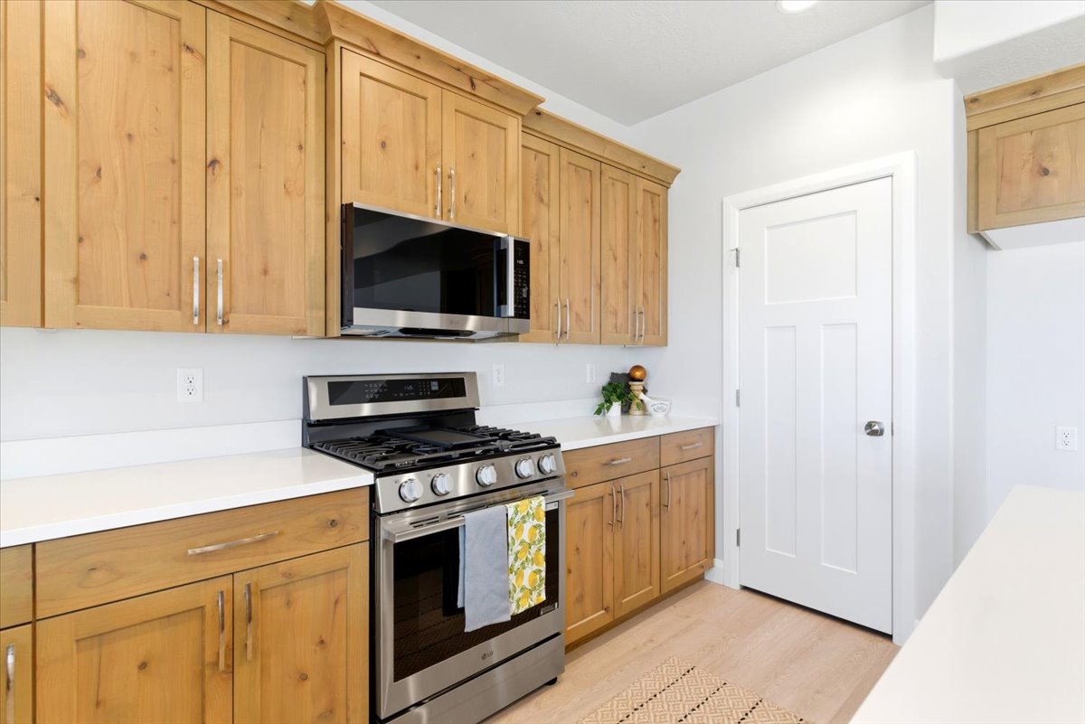 Light wood-finish cabinetry complemented by white countertops