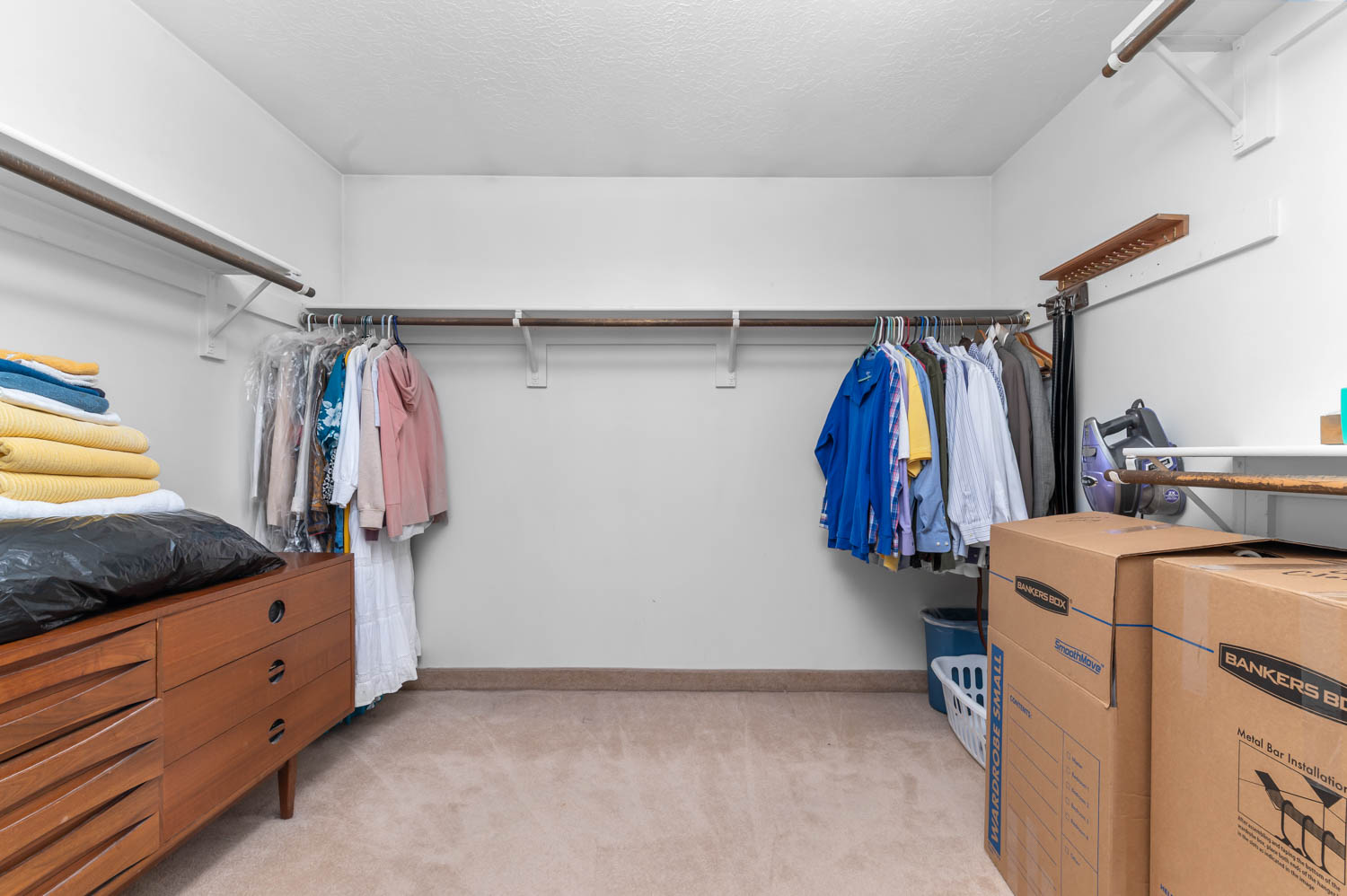 Spacious walk-in closet featuring multiple shelving units and clothing rods for ample organization