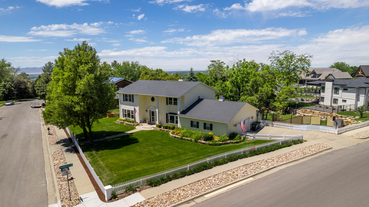 Two-story residence featuring a light-colored exterior and dark shingle roof