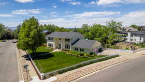 Two-story residence featuring a light-colored exterior and dark shingle roof