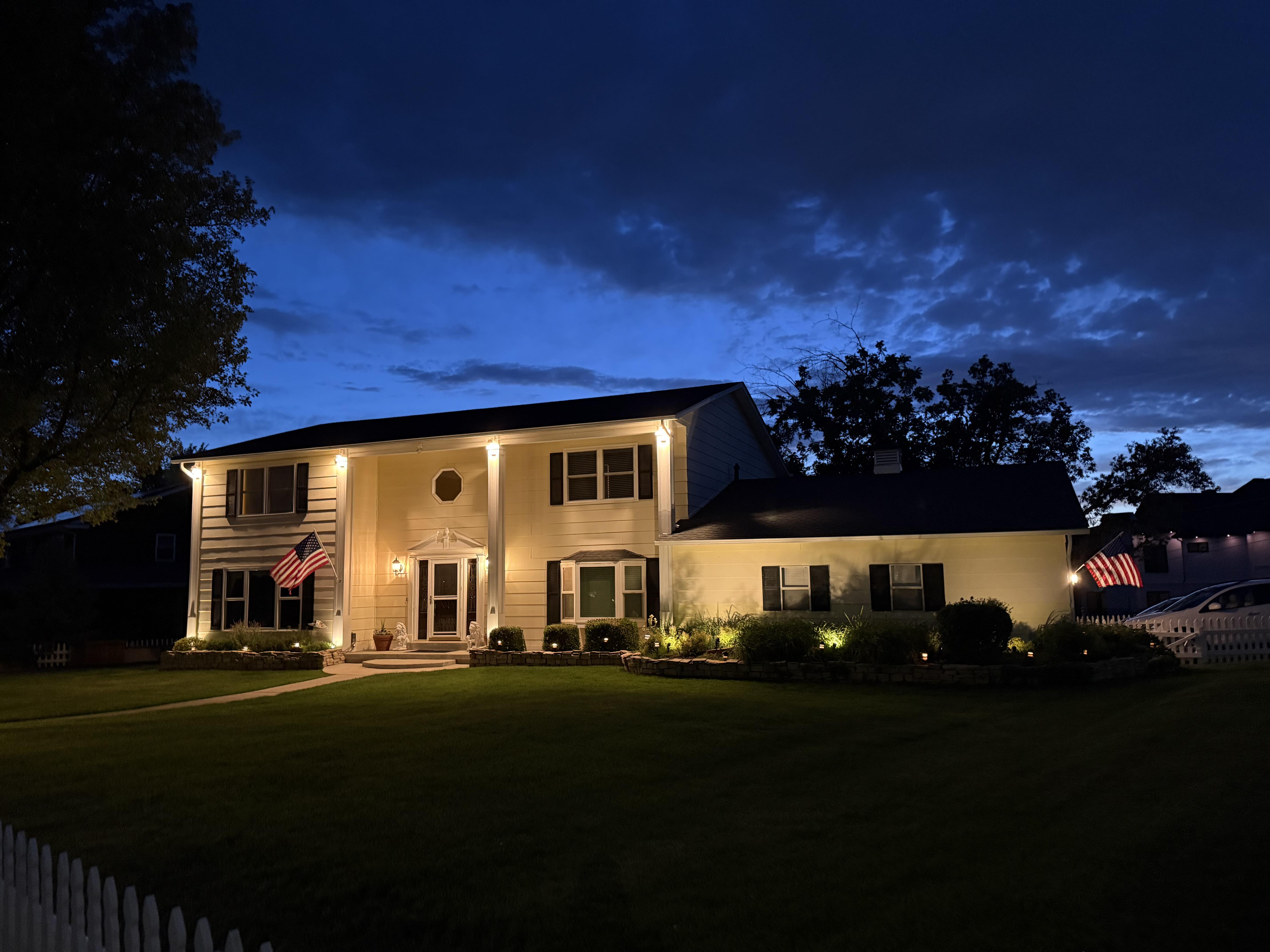 Traditional-style residence featuring a prominent front entrance with sidelights, transom window, and dual columns