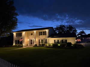 Traditional-style residence featuring a prominent front entrance with sidelights, transom window, and dual columns