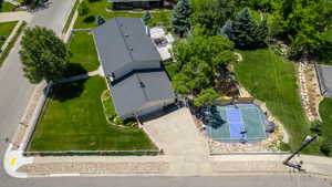 Expansive corner lot featuring a two-story residence with an attached garage, a dedicated sport court, and mature landscaping