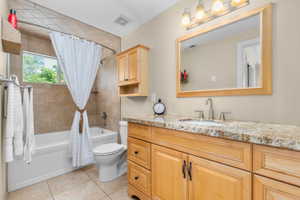 Bathroom with a built-in tub and tiled shower surround, featuring a window and recessed shelf