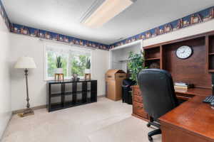 Built-in wooden desk with integrated shelving, overhead fluorescent lighting, and a large window providing exterior light
