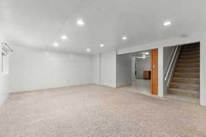 Spacious room with plush carpet flooring, recessed lighting, and a neutral color palette