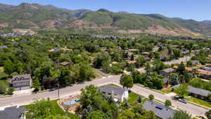 Residential neighborhood featuring mature trees and mountain backdrops