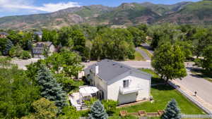 Two-story property featuring a rear deck with a pergola, a second-story balcony, and mature landscaping