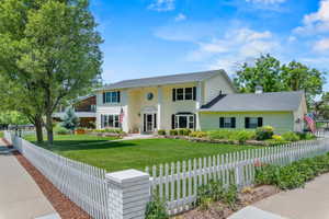 Traditional-style residence with light-colored siding and a contrasting dark roof