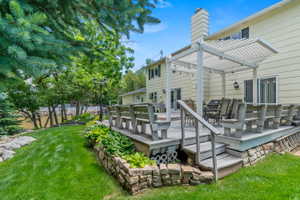 Expansive rear deck featuring a white pergola, built-in benches, and direct access to the interior