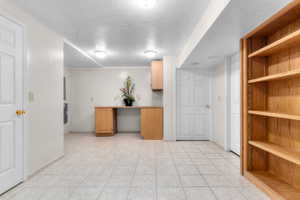 Spacious room featuring light-toned tile flooring and recessed lighting