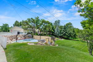Expansive outdoor space featuring a half-court sports court, a stone retaining wall, and a verdant lawn area