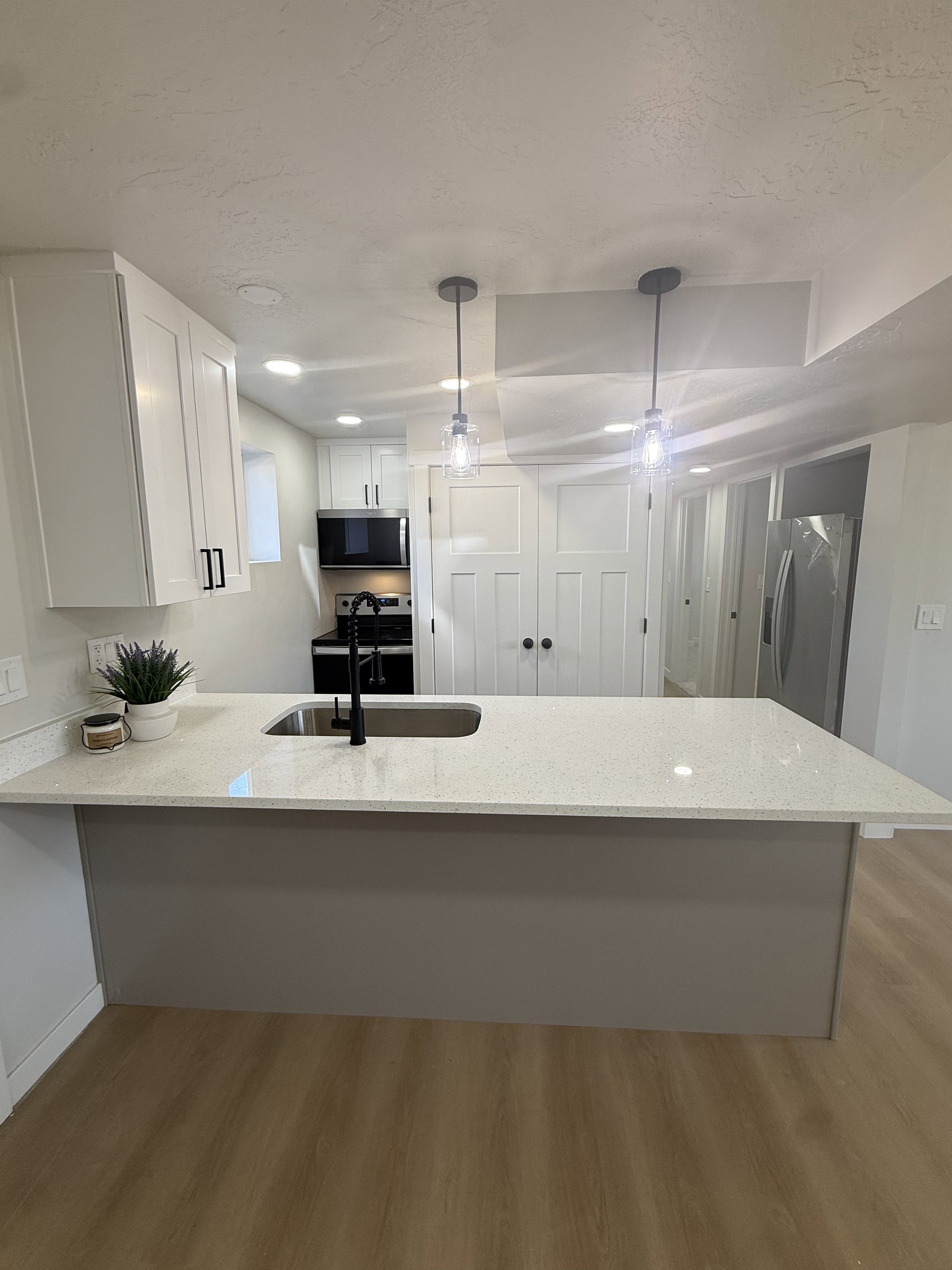 Kitchen island with light-toned countertop and integrated sink