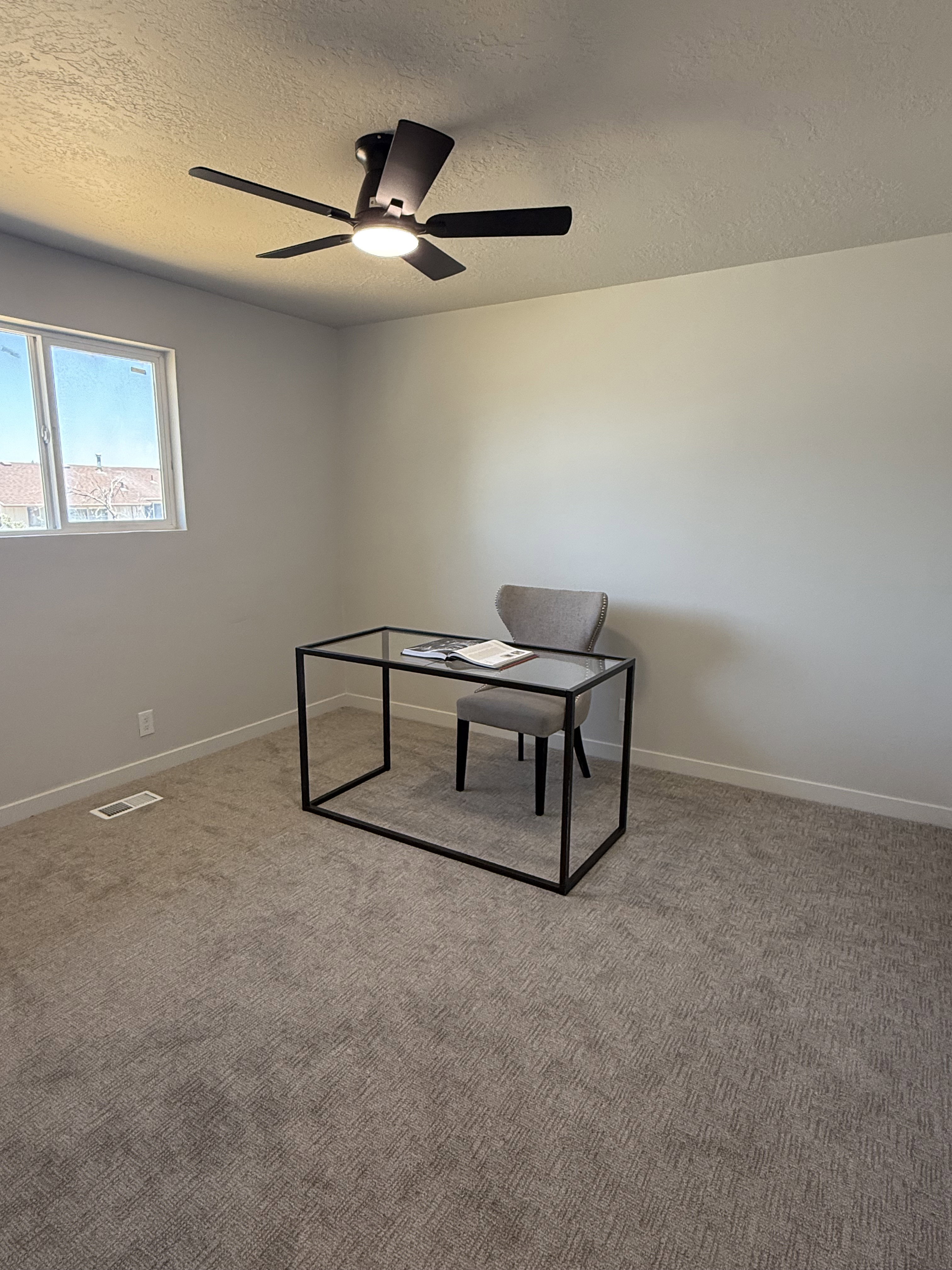 Light-filled room featuring neutral wall tones and textured carpeting