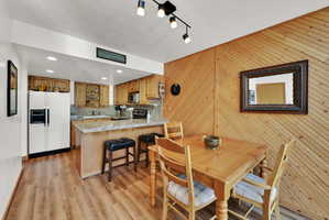 Open-concept kitchen and dining area featuring wood-finish flooring