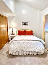 Room featuring a vaulted ceiling and light-colored carpeting