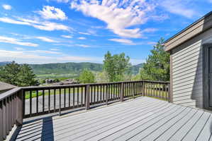 Deck View looking west at Nordic Valley Ski Resort.  Spacious outdoor deck featuring gray composite decking, a dark wood railing, and a siding exterior